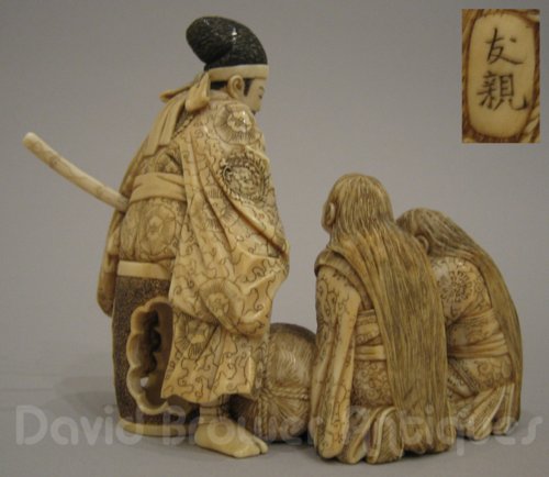 A fine Japanese ivory group of seated Samurai with 2 women