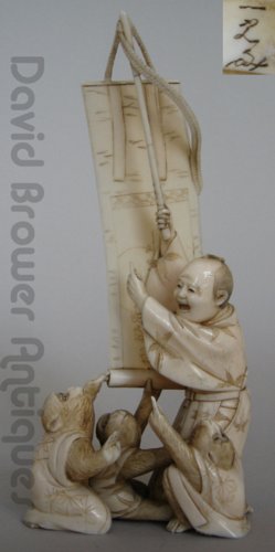 Japanese ivory okimono of a monkey trainer and scroll